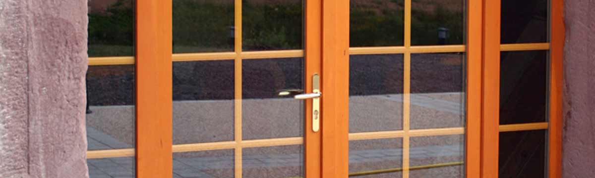 Cette porte sur-mesure est en aluminium.